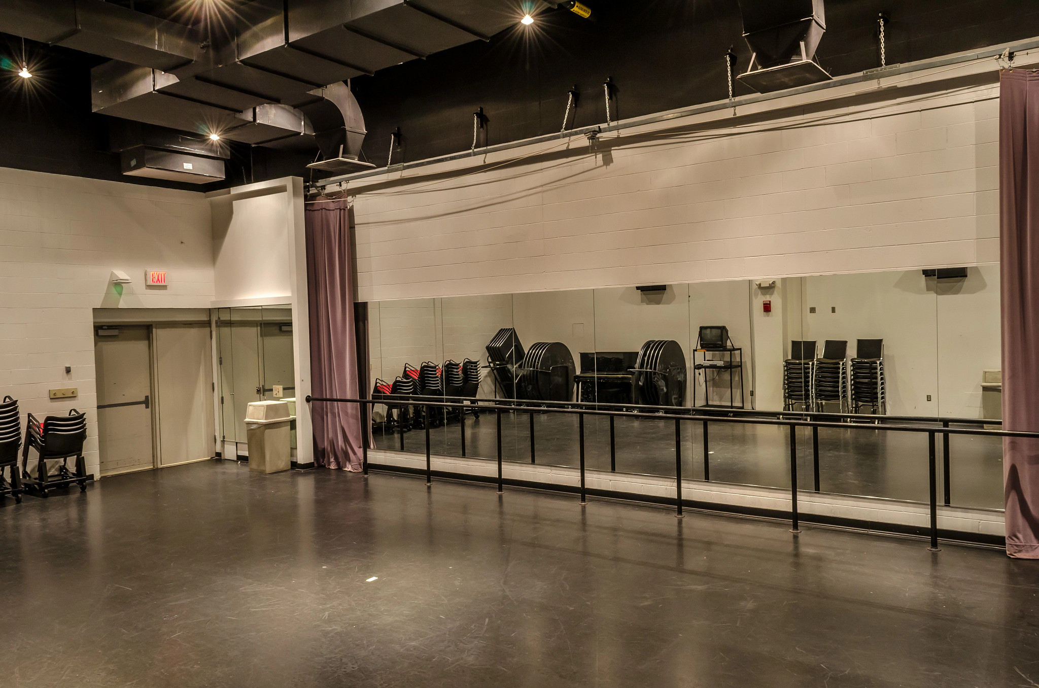 Dance studio with large mirrors and a ballet bar on the wall